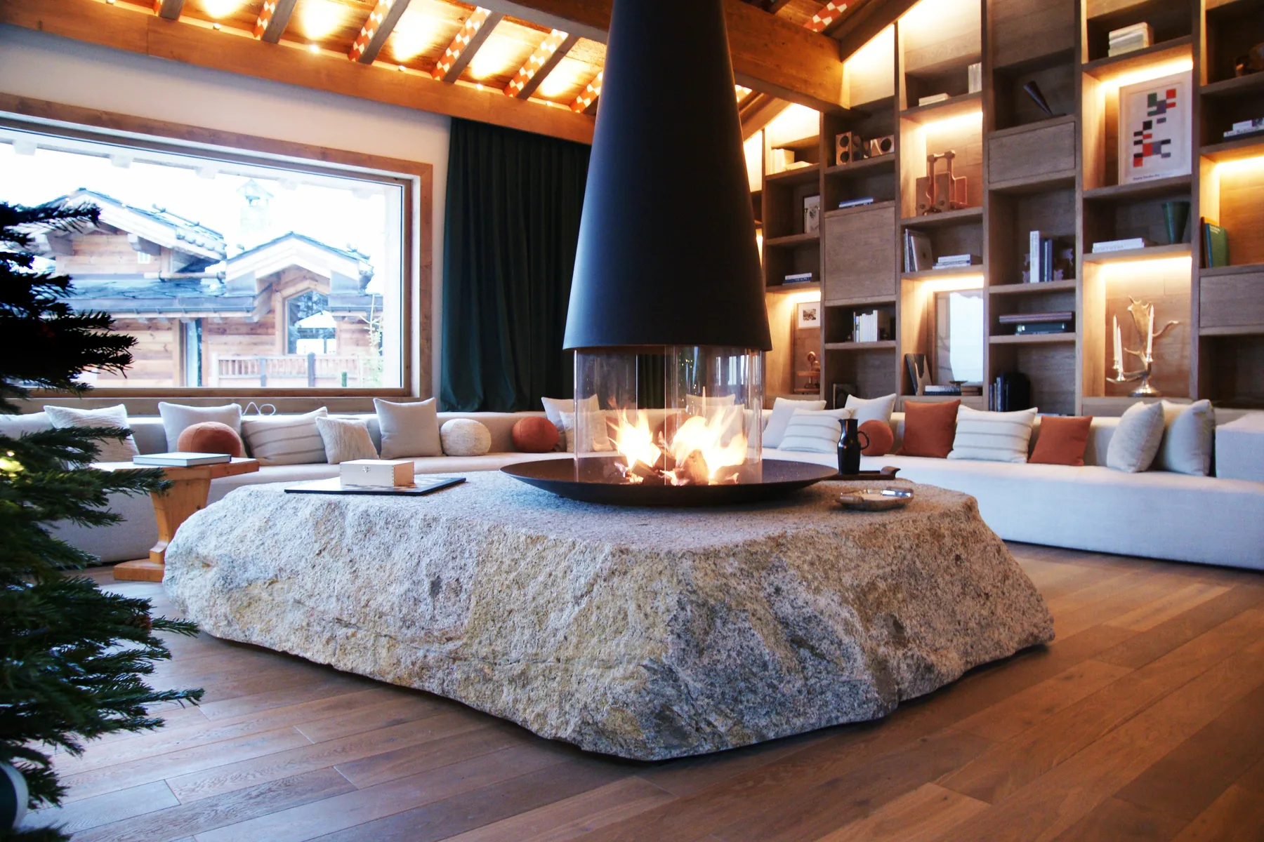 Salon avec table monolithe en pierre naturelle et foyer central