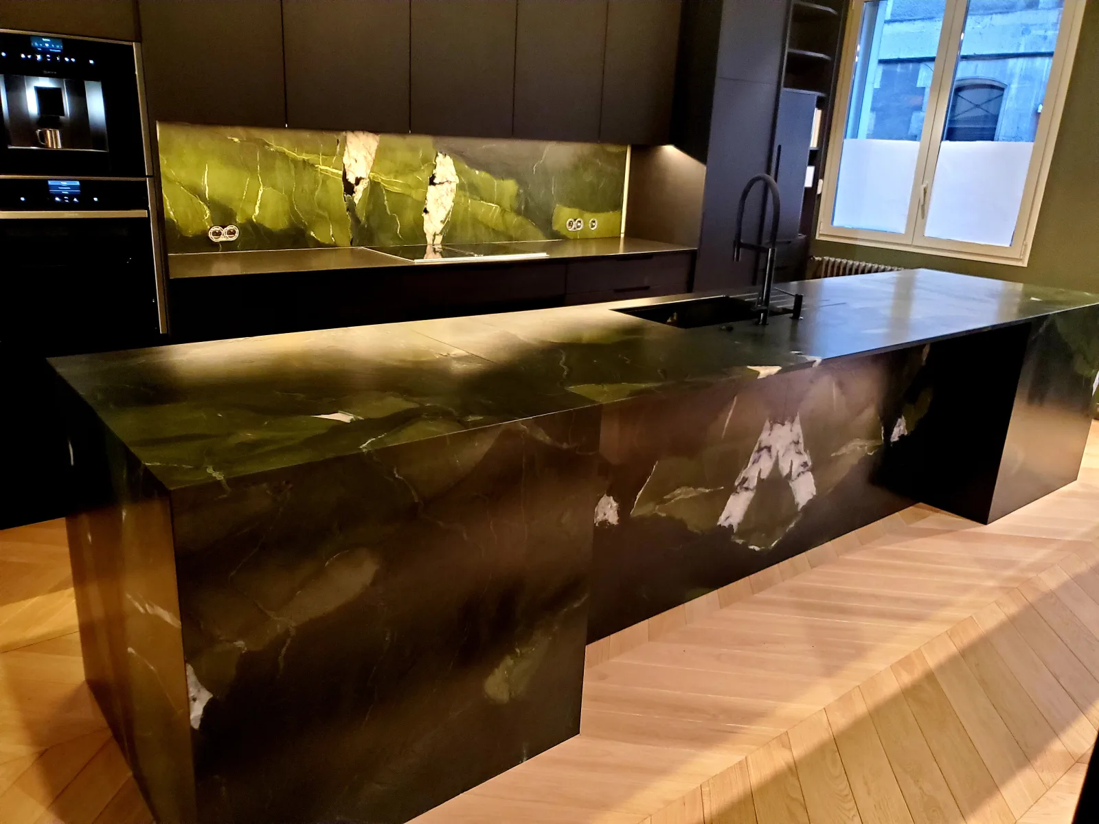 Îlot de cuisine et crédence en pierre sombre veinée de vert, réalisation Bâcle Pierre & Granit à Angoulême